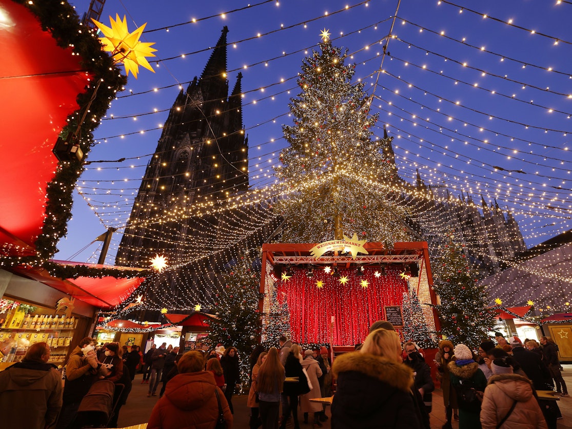 Besucher gehen über den Weihnachtsmarkt auf dem Roncalliplatz am Kölner Dom.