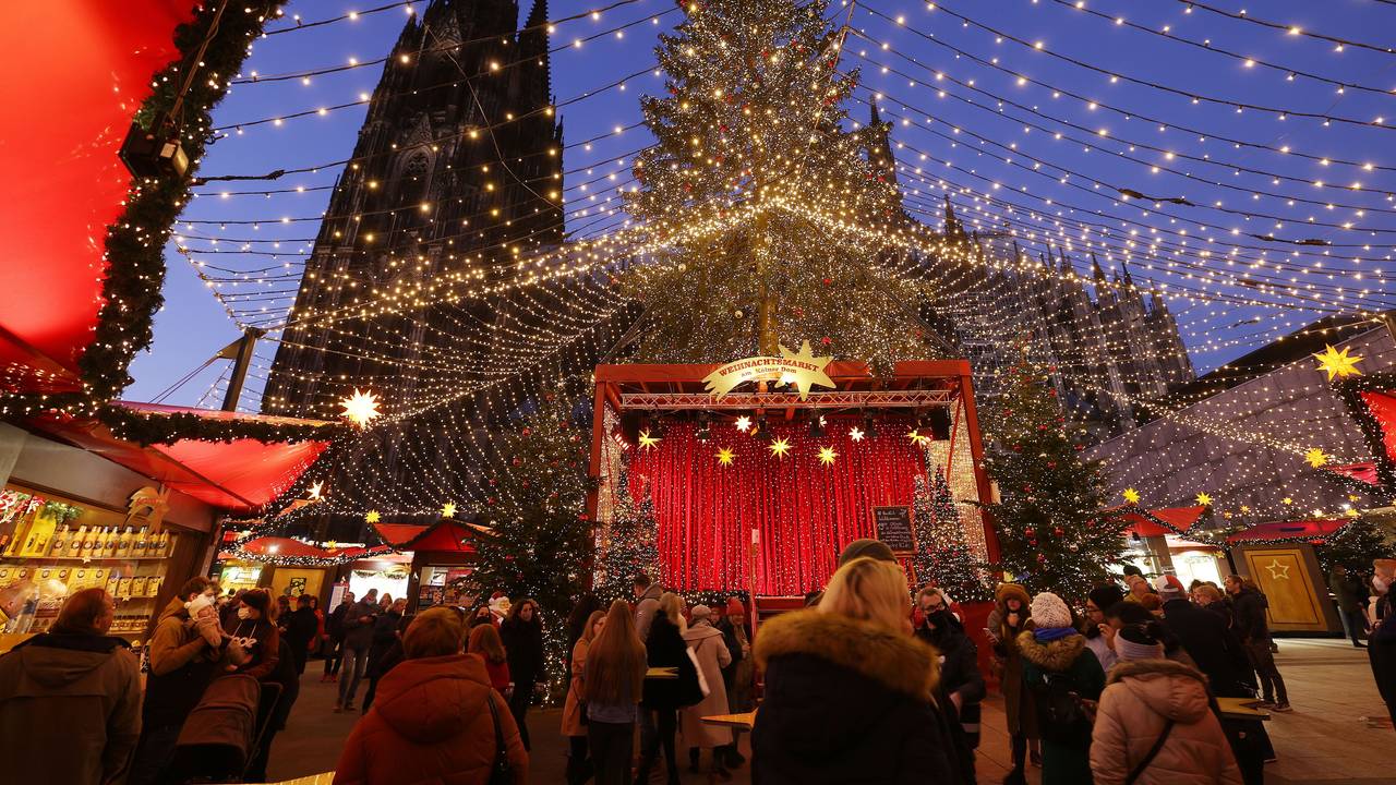 Besucher gehen über den Weihnachtsmarkt auf dem Roncalliplatz am Kölner Dom.