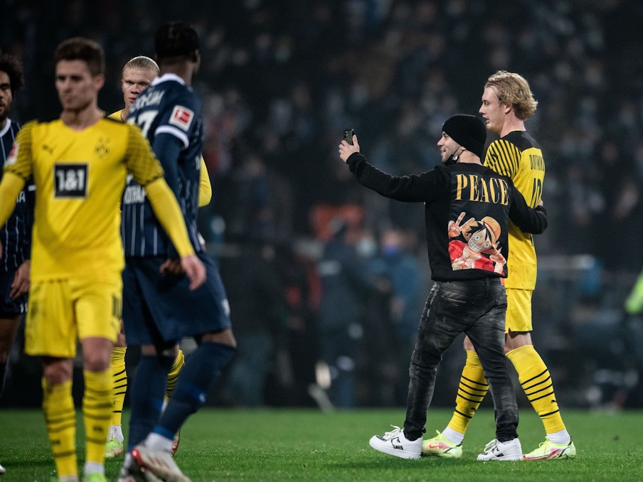 Flitzer Momo steht in Bochum mit Julian Brandt auf dem Rasen