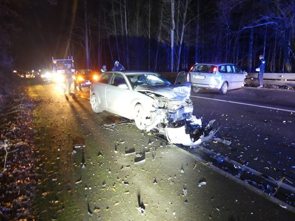 Zwei Autowracks auf der Straße, daneben Einsatzkräfte.