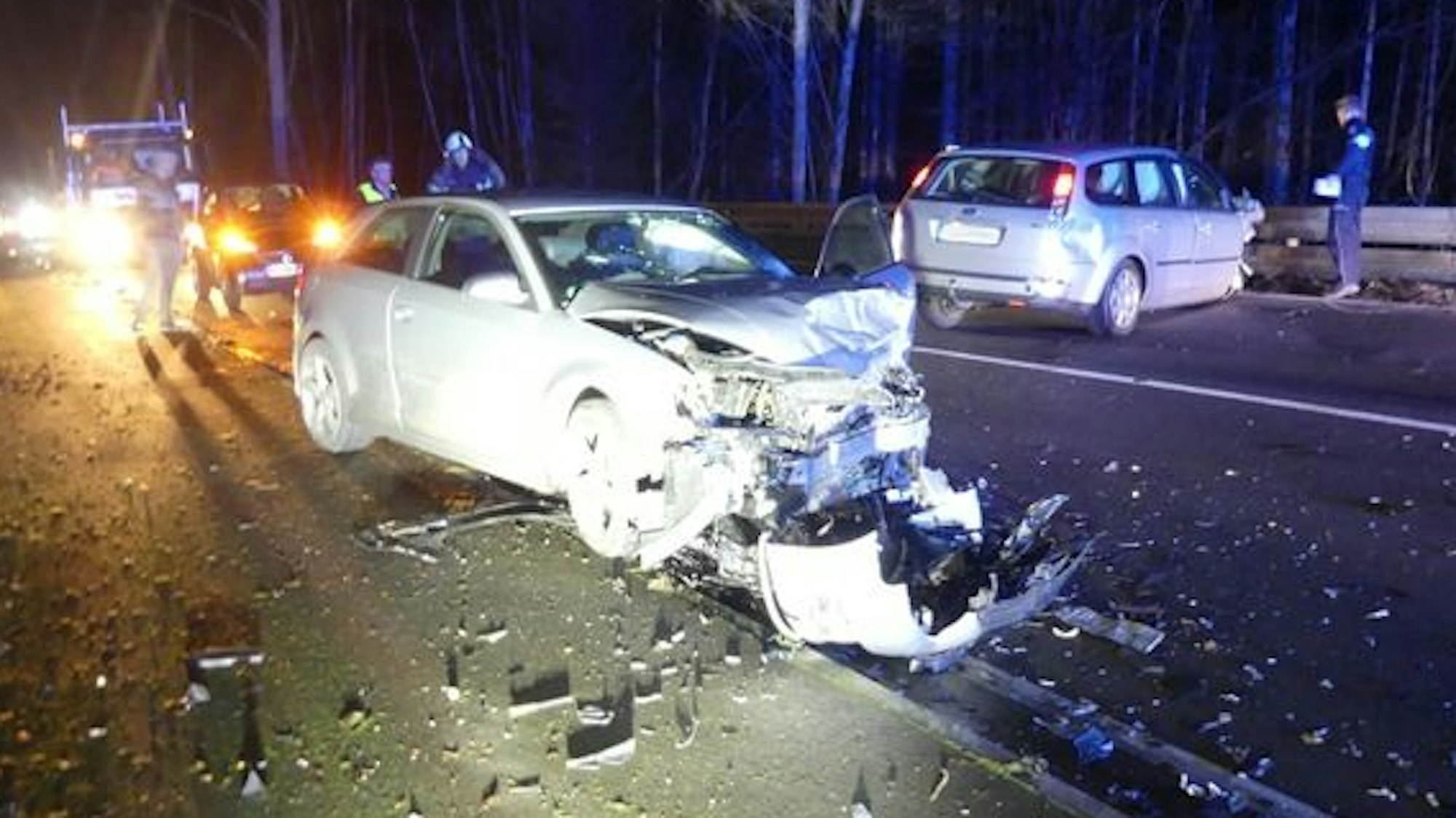 Zwei Autowracks auf der Straße, daneben Einsatzkräfte.