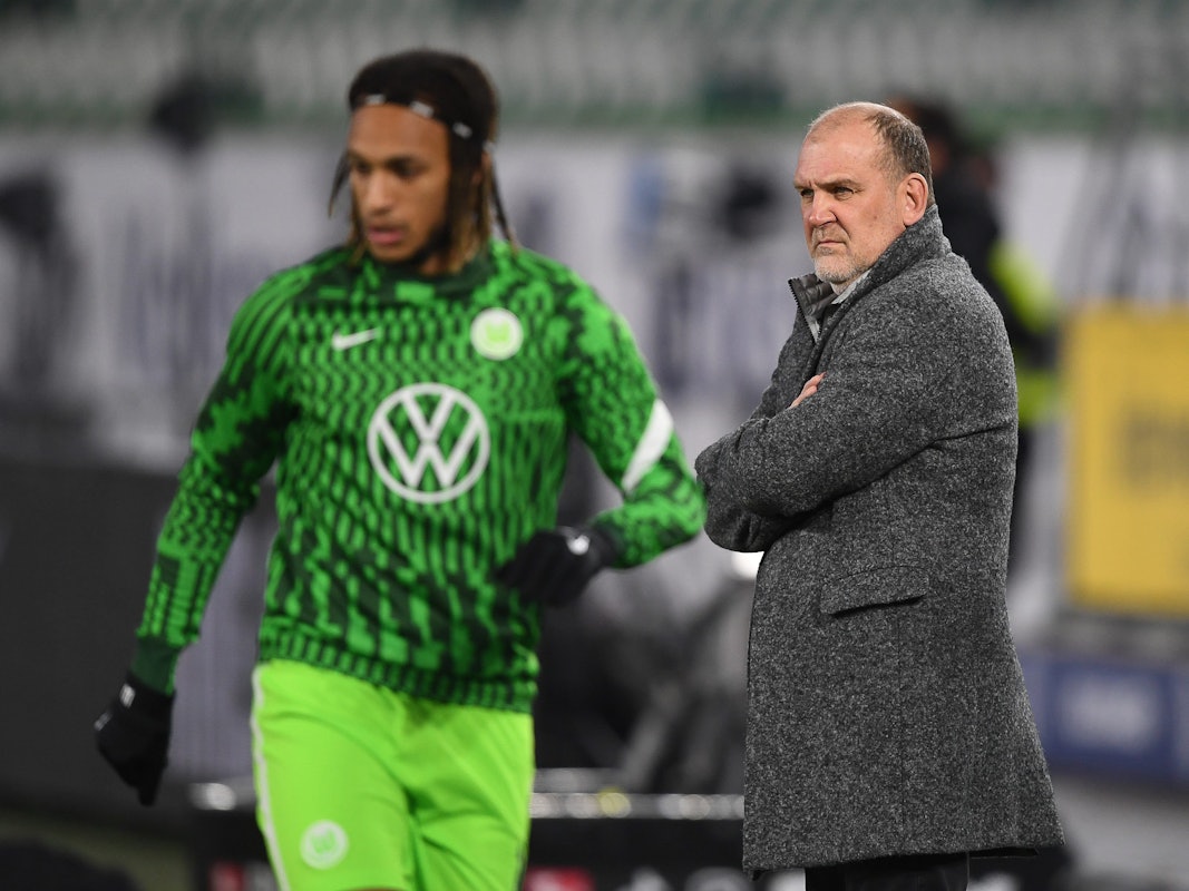 Jörg Schmadtke, Geschäftsführer Sport vom VfL Wolfsburg, im Stadion. Links läuft Wolfsburgs Kevin Mbabu.