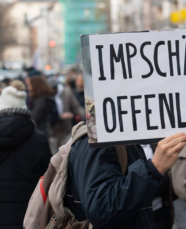 Ein Teilnehmer einer Demonstration hält ein Schild mit der Aufschrift „Impfschäden offenlegen“ in der Hand.