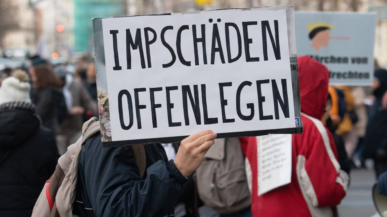 Ein Teilnehmer einer Demonstration hält ein Schild mit der Aufschrift „Impfschäden offenlegen“ in der Hand.