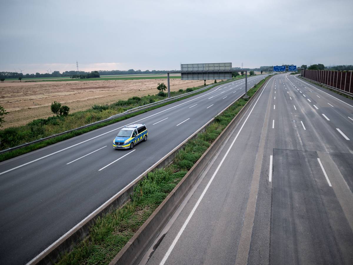 Ein Wagen der Polizei fährt über die gesperrte Autobahn A1 nahe Blessem in Erftstadt.