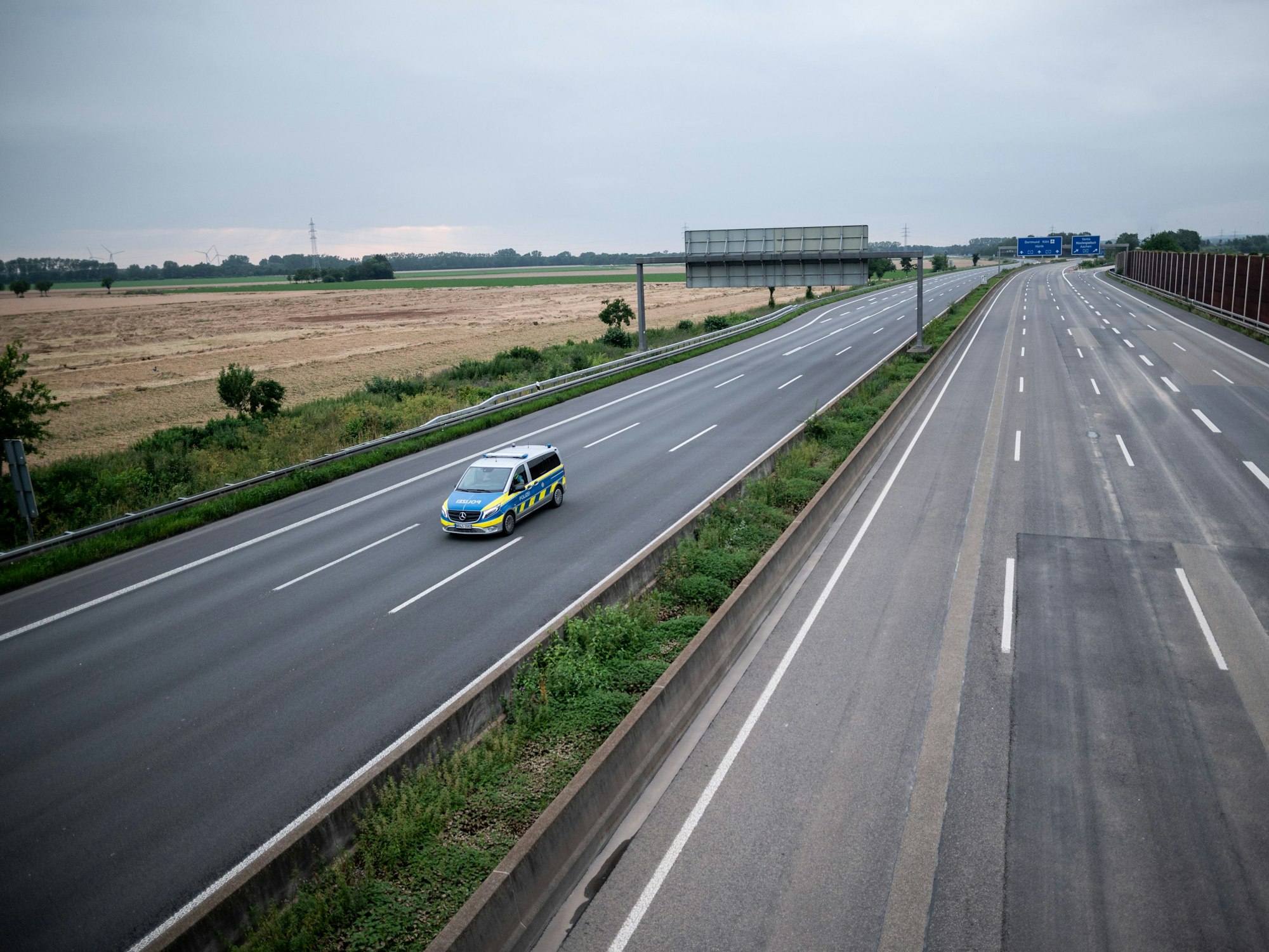 Ein Wagen der Polizei fährt über die gesperrte Autobahn A1 nahe Blessem in Erftstadt.