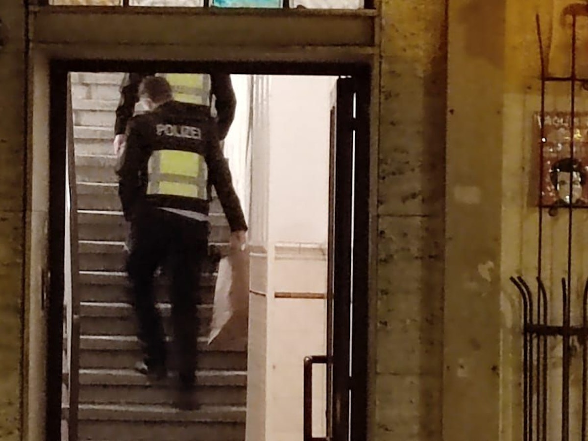 Zwei Polizisten gehen in einem Hausflur die Treppe hoch.