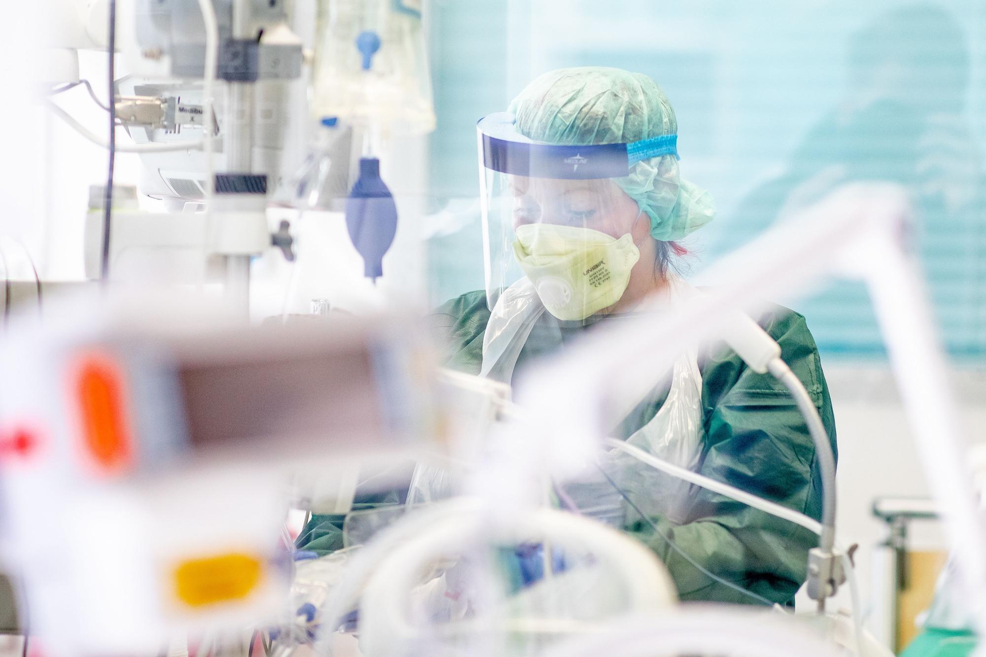Corona in Köln: Eine Krankenpflegerin arbeitet in Schutzkleidung in einem Krankenzimmer auf der Intensivstation des Uniklinikums.
