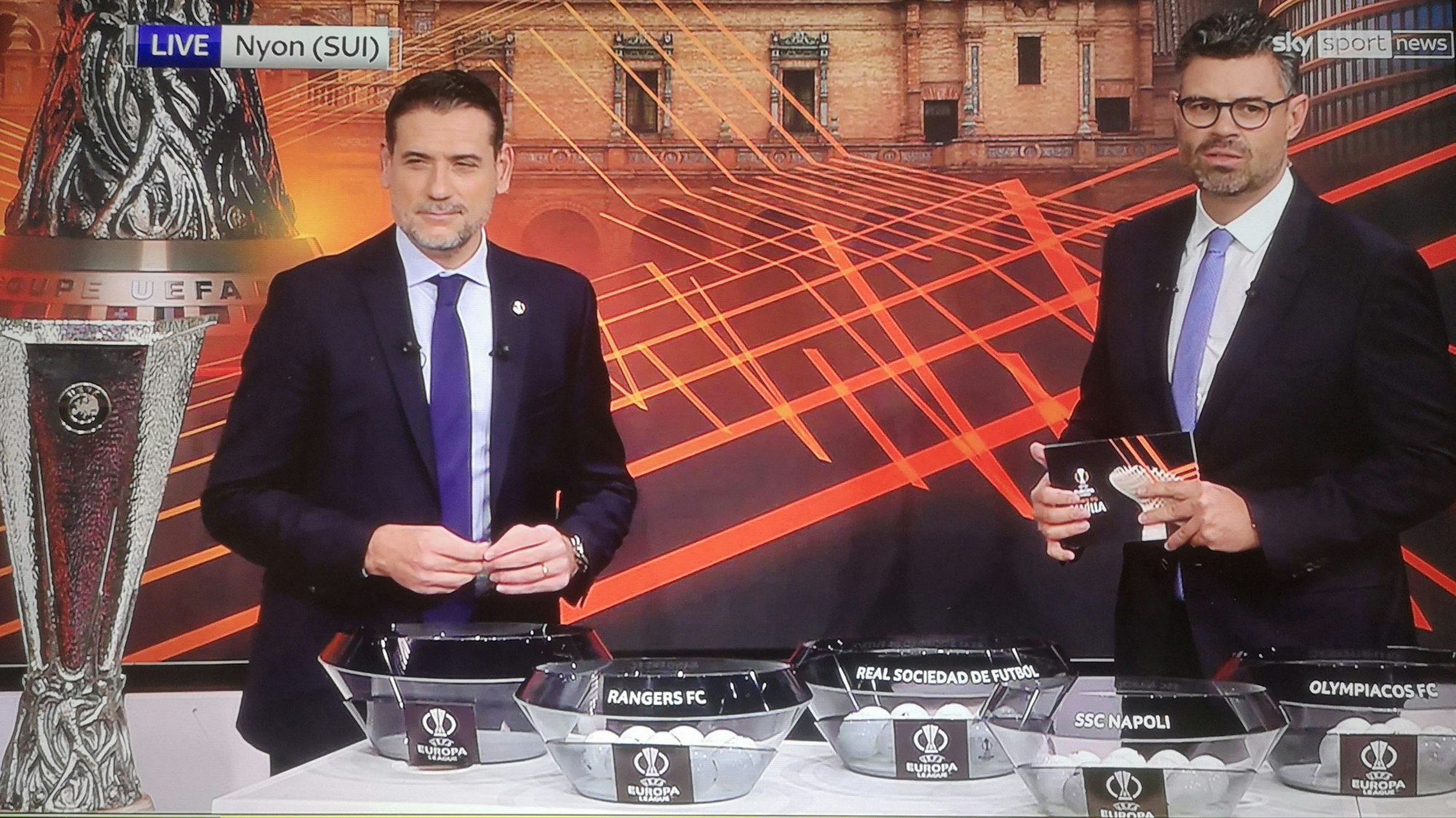 Andrés Palop und Pedro Pinto stehen bei der Auslosung der Europa League vor den Lostöpfen.