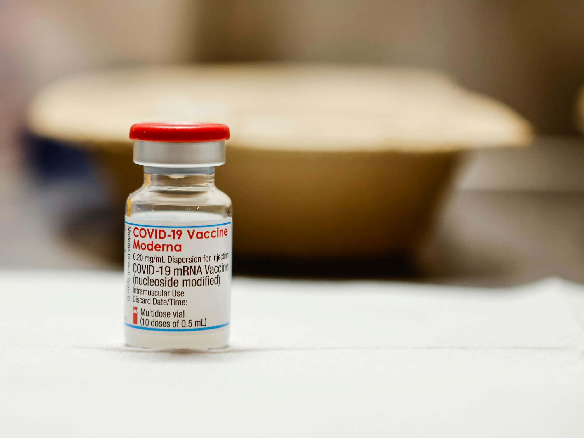 Eine Ampulle gefüllt mit dem Impfstoff «Moderna» steht auf einem Tisch in einem Impfzentrum. (Zu dpa: «Impfen rund um die Uhr - Aachen startet 60-Stunden-Aktion») +++ dpa-Bildfunk +++