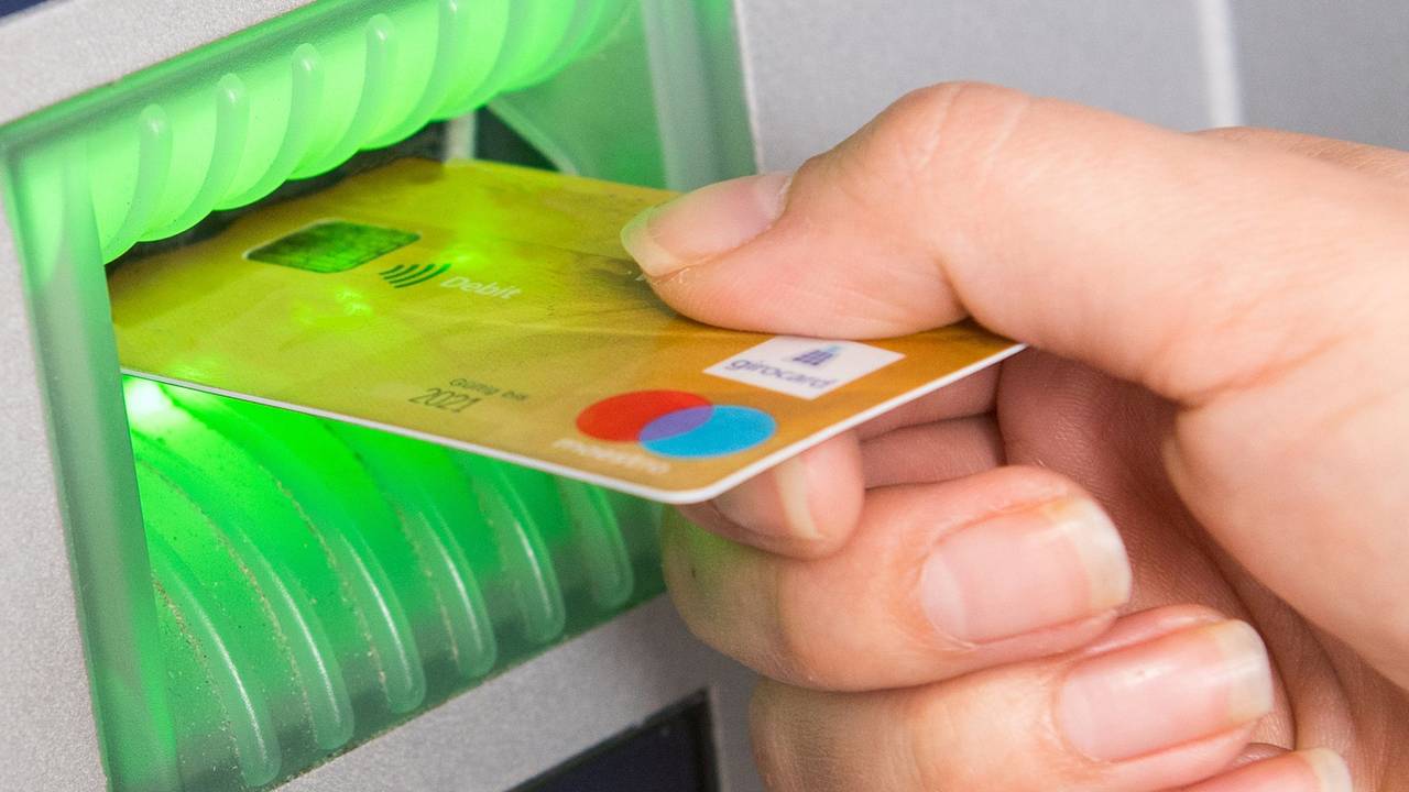 Kunden der Direktbanken ING und 1822direkt müssen ab 2022 Gebühren für ihre Girocard bezahlen. Das Foto zeigt eine Frau, die ihre Girocard in einen Geldautomaten schiebt.
