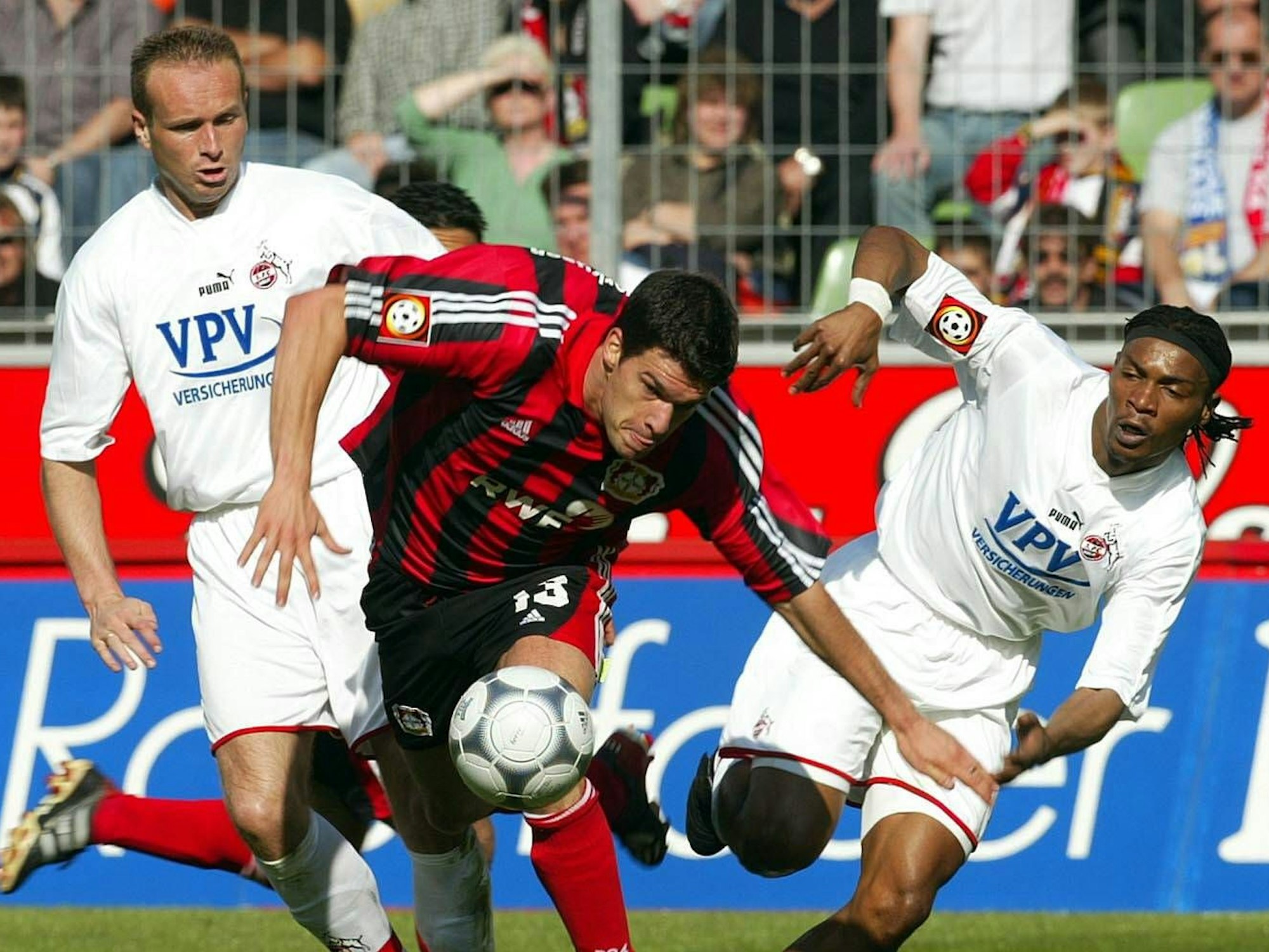 Dirk Lottner und Rigobert Song versuchen, Michael Ballack den Ball abzuluchsen.