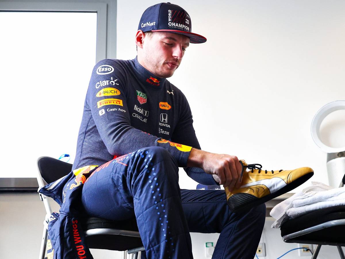 Max Verstappen zieht sich seine neuen goldenen Schuhe an.
