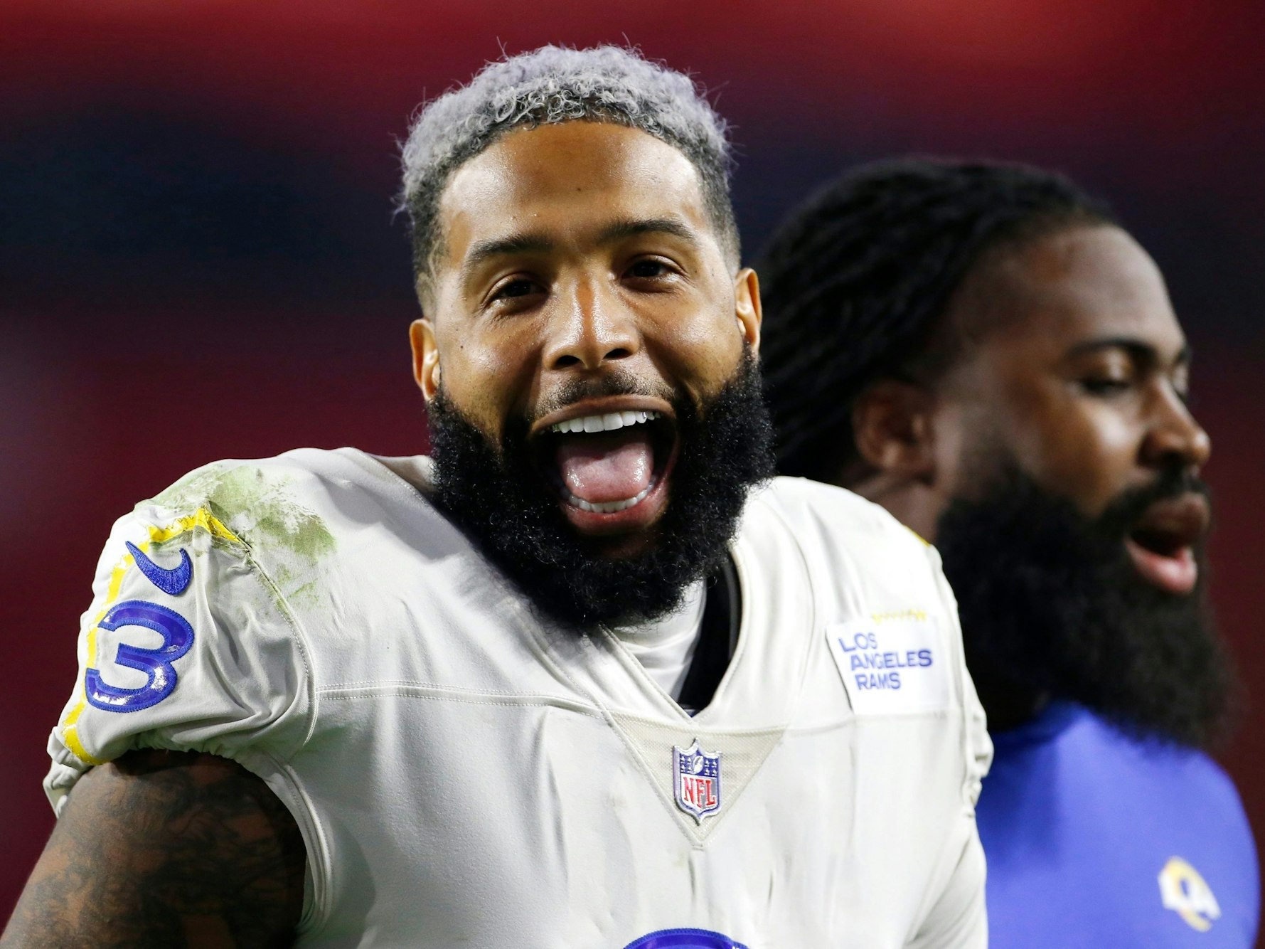 Odell Beckham Jr. steht im Trikot der Los Angeles Rams auf dem Feld, hat den Mund geöffnet und lacht.