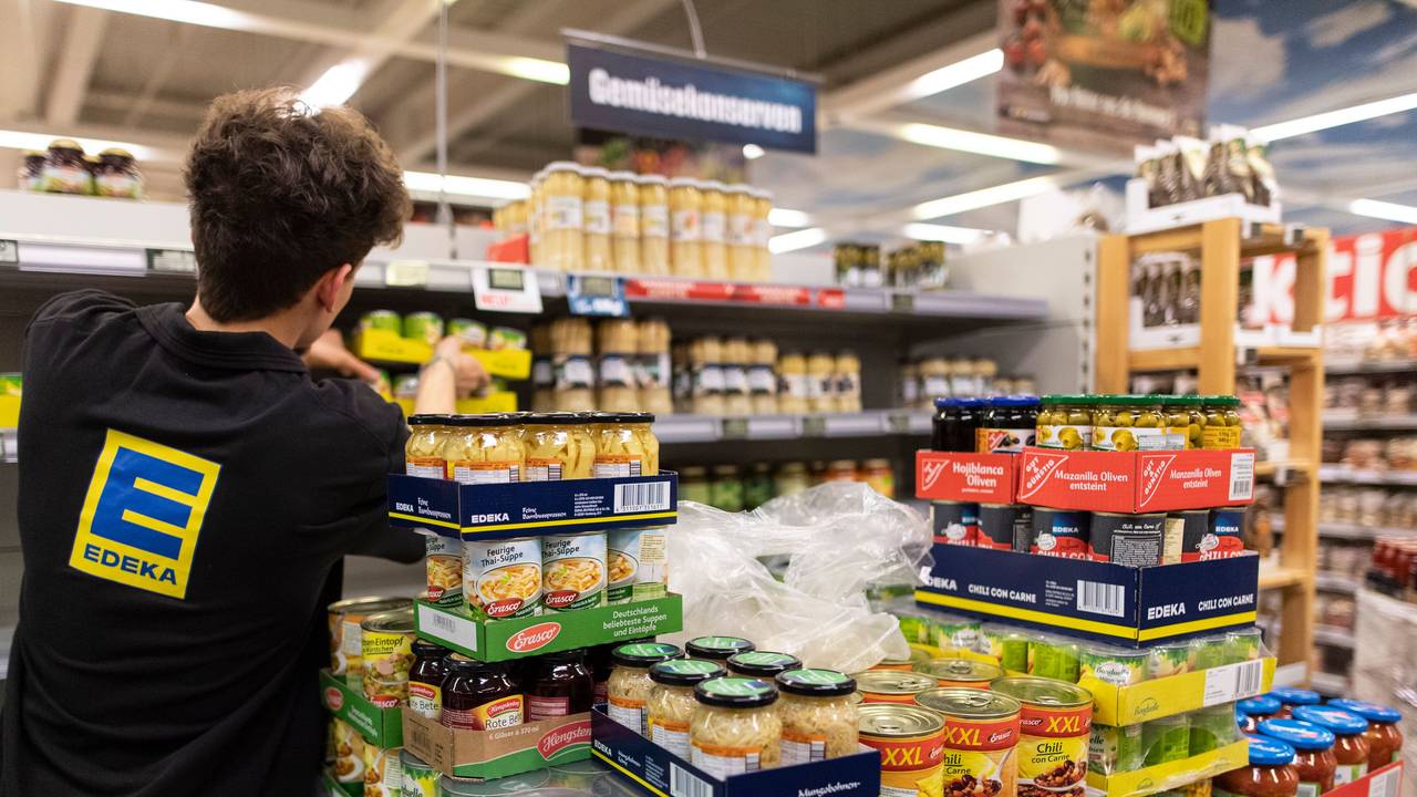 Ein Mitarbeiter von Edeka füllt ein Regal auf.