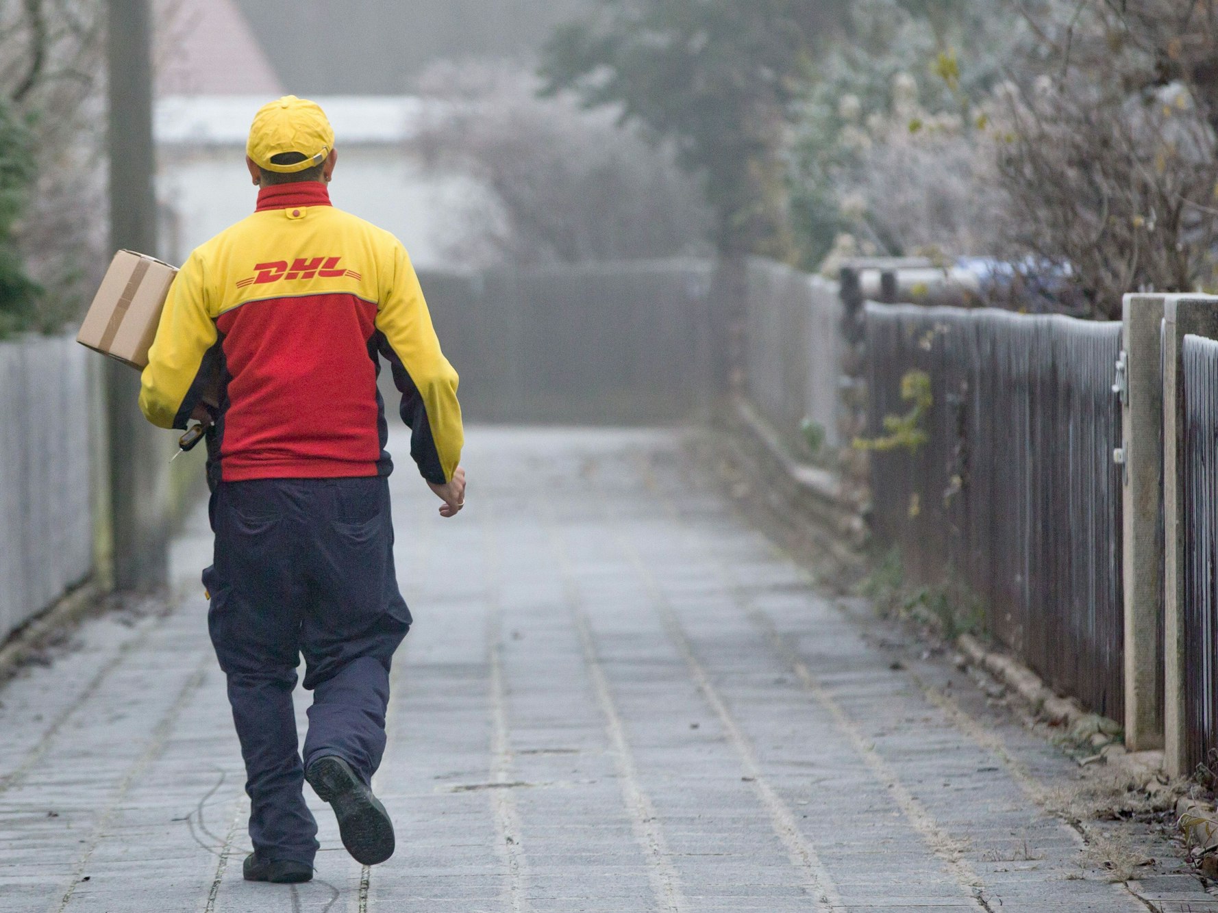 Ein DHL-Paketzusteller liefert am 09.12.2014 in seinem Zustellbezirk in Nürnberg (Bayern) Sendungen aus. Foto: Daniel Karmann/dpa (zu dpa "Post beschäftigt 9000 Zusteller in neuen Paketgesellschaften")