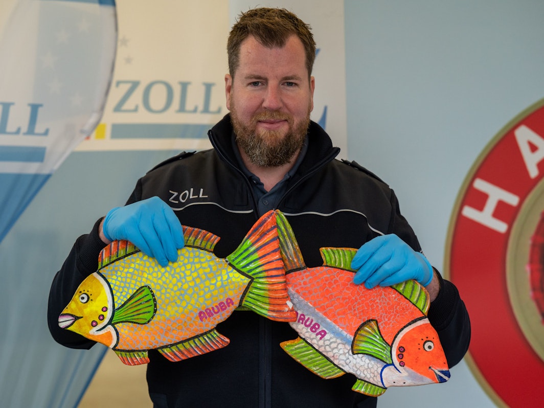 Der Zollbeamte Jens Ahland zeigt kuriose Drogenverstecke, wie zwei bunte Fische, die aus gepresstem Kokain bestehen.