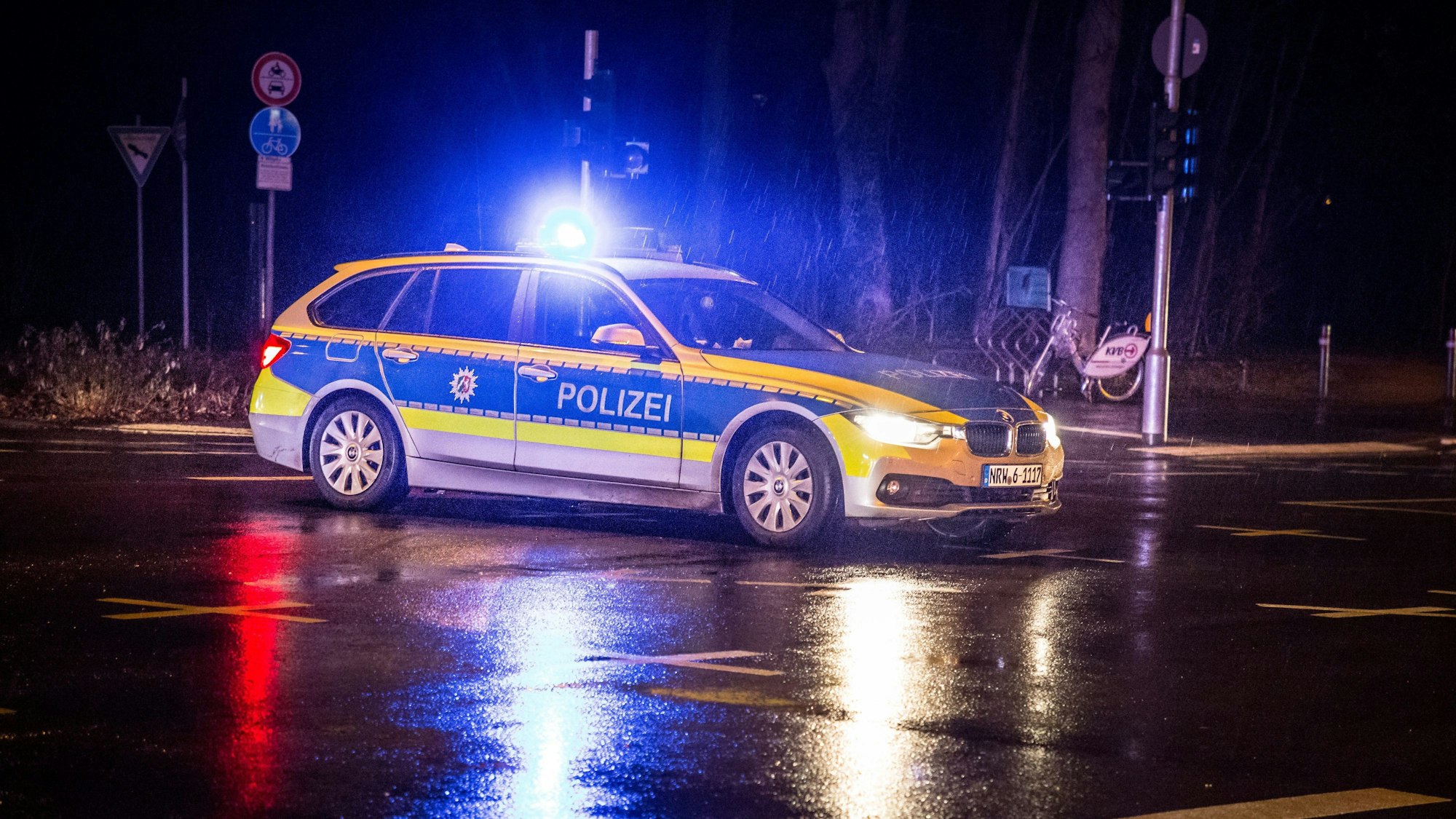 Polizeiwagen mit Blaulicht auf einer verregneten Straße
