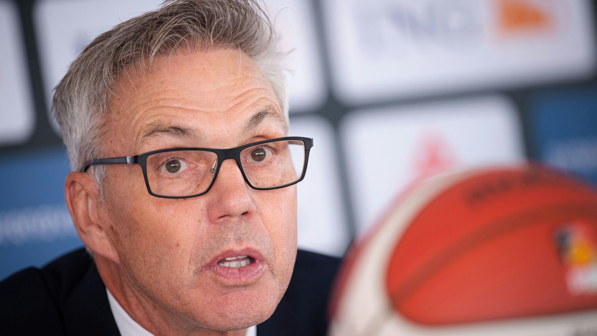 Gordon Herbert sitzt bei einer Pressekonferenz am Rednerpult.