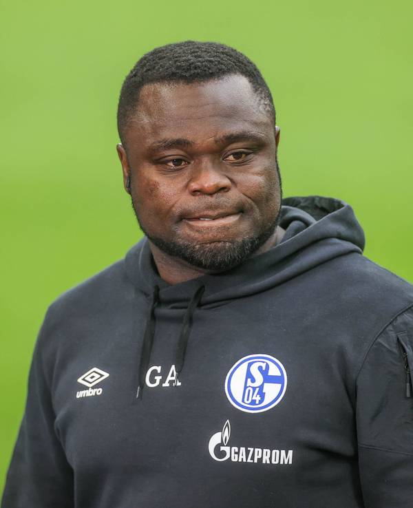 Gerald Asamoah steht im Schalke-Hoodie auf dem Platz.