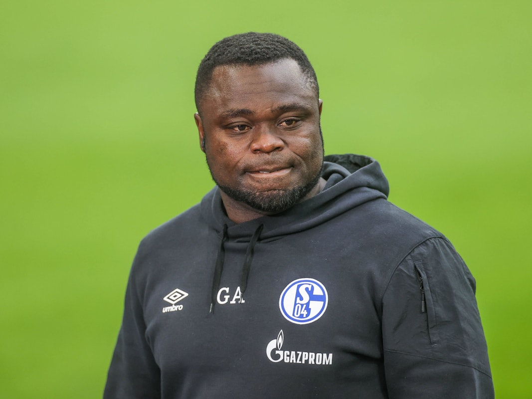 Gerald Asamoah steht im Schalke-Hoodie auf dem Platz.
