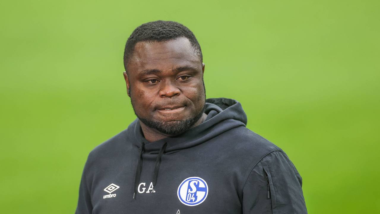 Gerald Asamoah steht im Schalke-Hoodie auf dem Platz.
