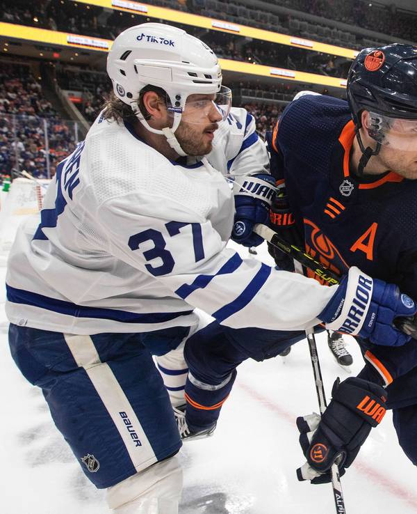 Timothy Liljegren von den Toronto Maple Leafs und Leon Draisaitl von den Edmonton Oilers befinden sich im Zweikampf, obwohl der Puck noch in der Ferne ist.