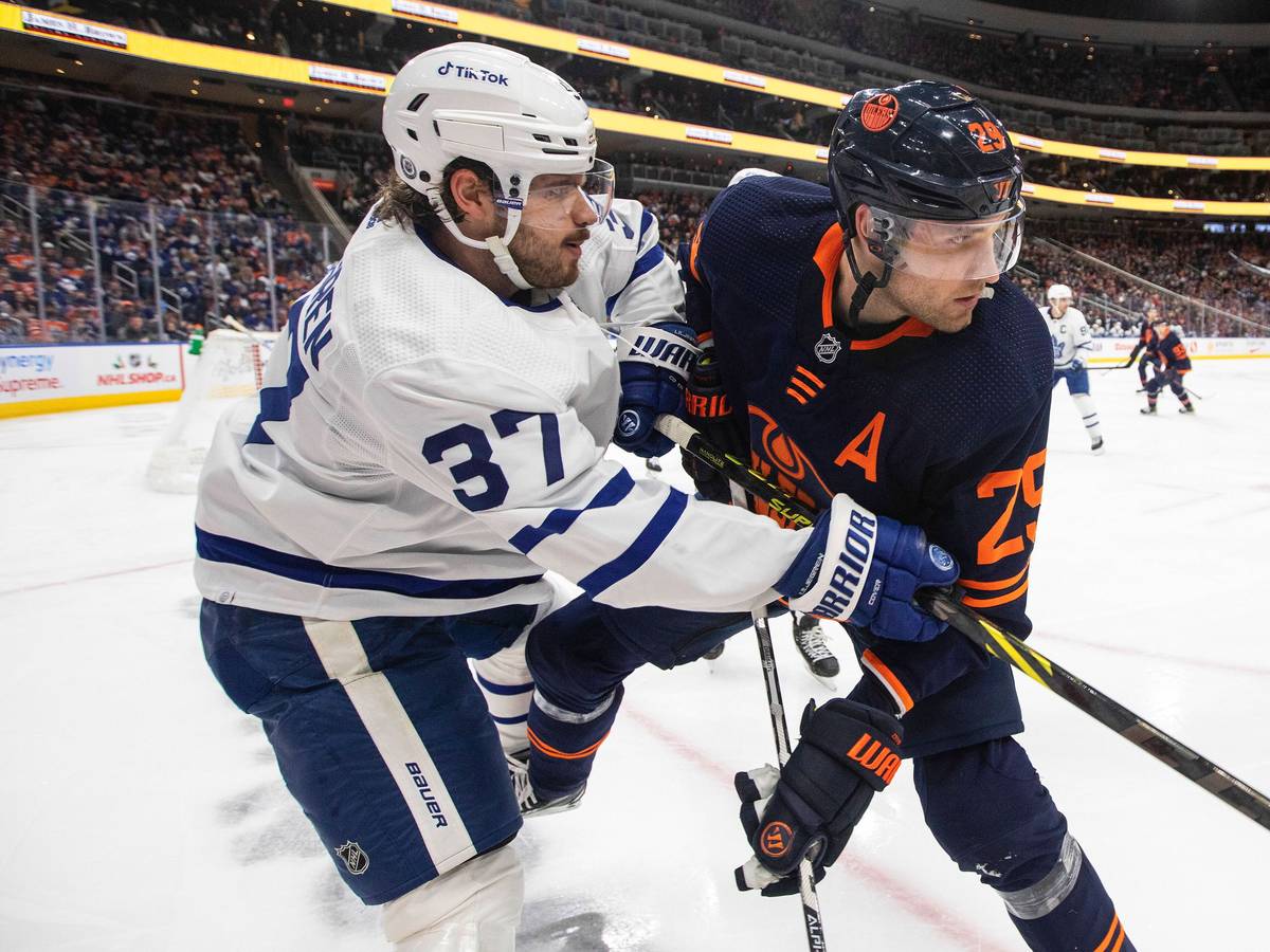 Timothy Liljegren von den Toronto Maple Leafs und Leon Draisaitl von den Edmonton Oilers befinden sich im Zweikampf, obwohl der Puck noch in der Ferne ist.