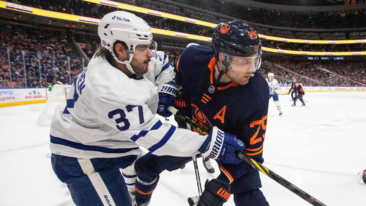 Timothy Liljegren von den Toronto Maple Leafs und Leon Draisaitl von den Edmonton Oilers befinden sich im Zweikampf, obwohl der Puck noch in der Ferne ist.