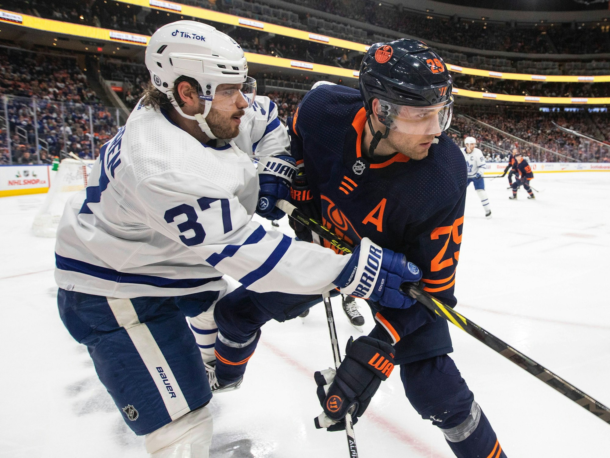 Timothy Liljegren von den Toronto Maple Leafs und Leon Draisaitl von den Edmonton Oilers befinden sich im Zweikampf, obwohl der Puck noch in der Ferne ist.