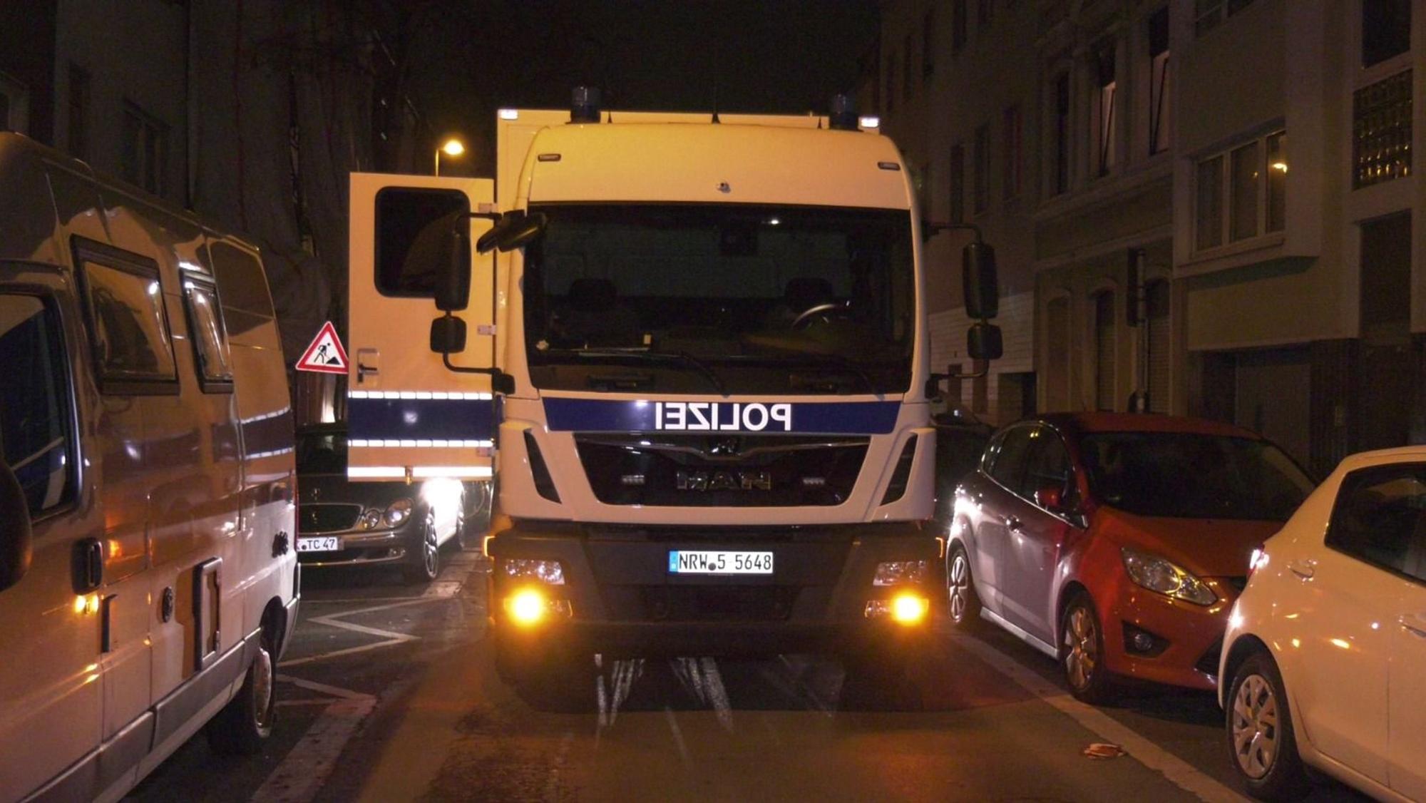 Ein Polizeifahrzeug steht auf einer Straße, eine Tür ist geöffnet.