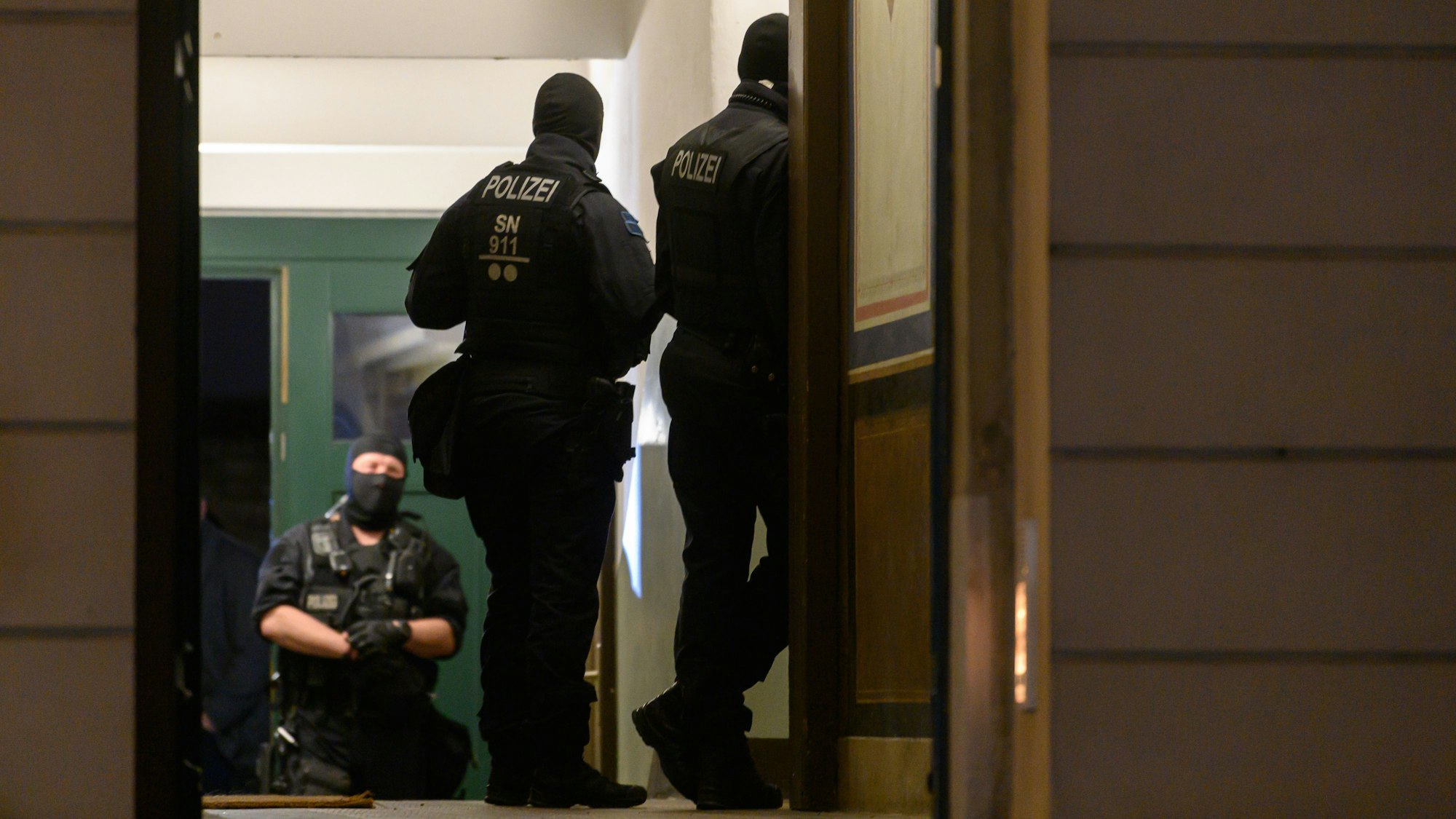 Polizisten stehen bei einer Razzia in einem Haus im Stadtteil Pieschen.