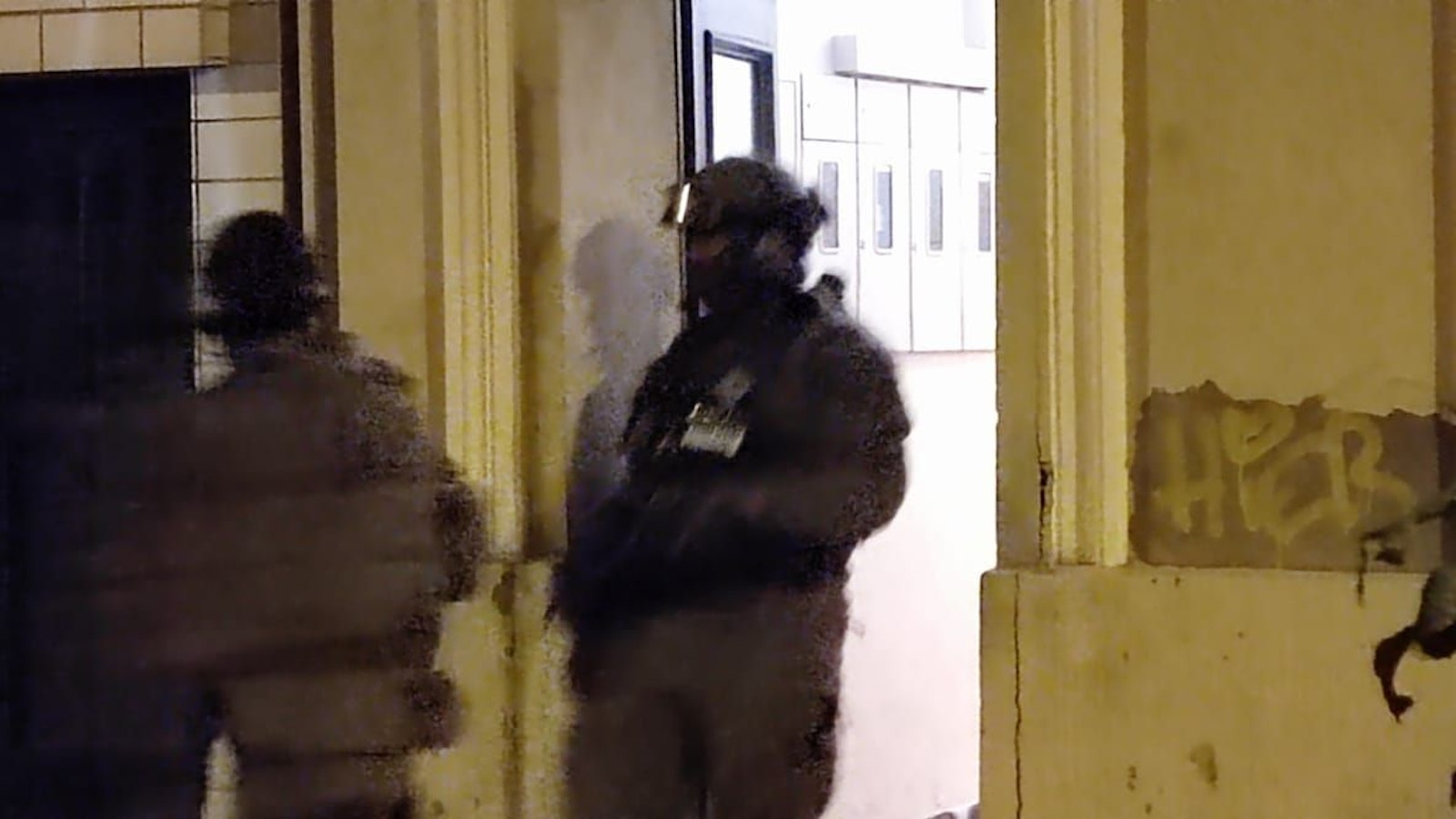 Zwei vermummte Kräfte der Spezialeinheit stehen vor einem Haus.