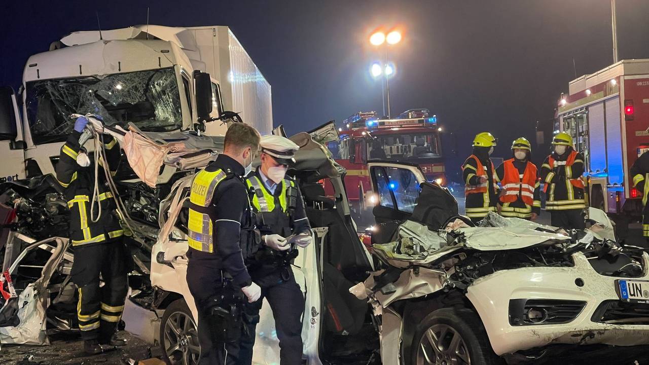 Polizisten stehen nach einem schweren Unfall an einem zerstörten Fahrzeug.