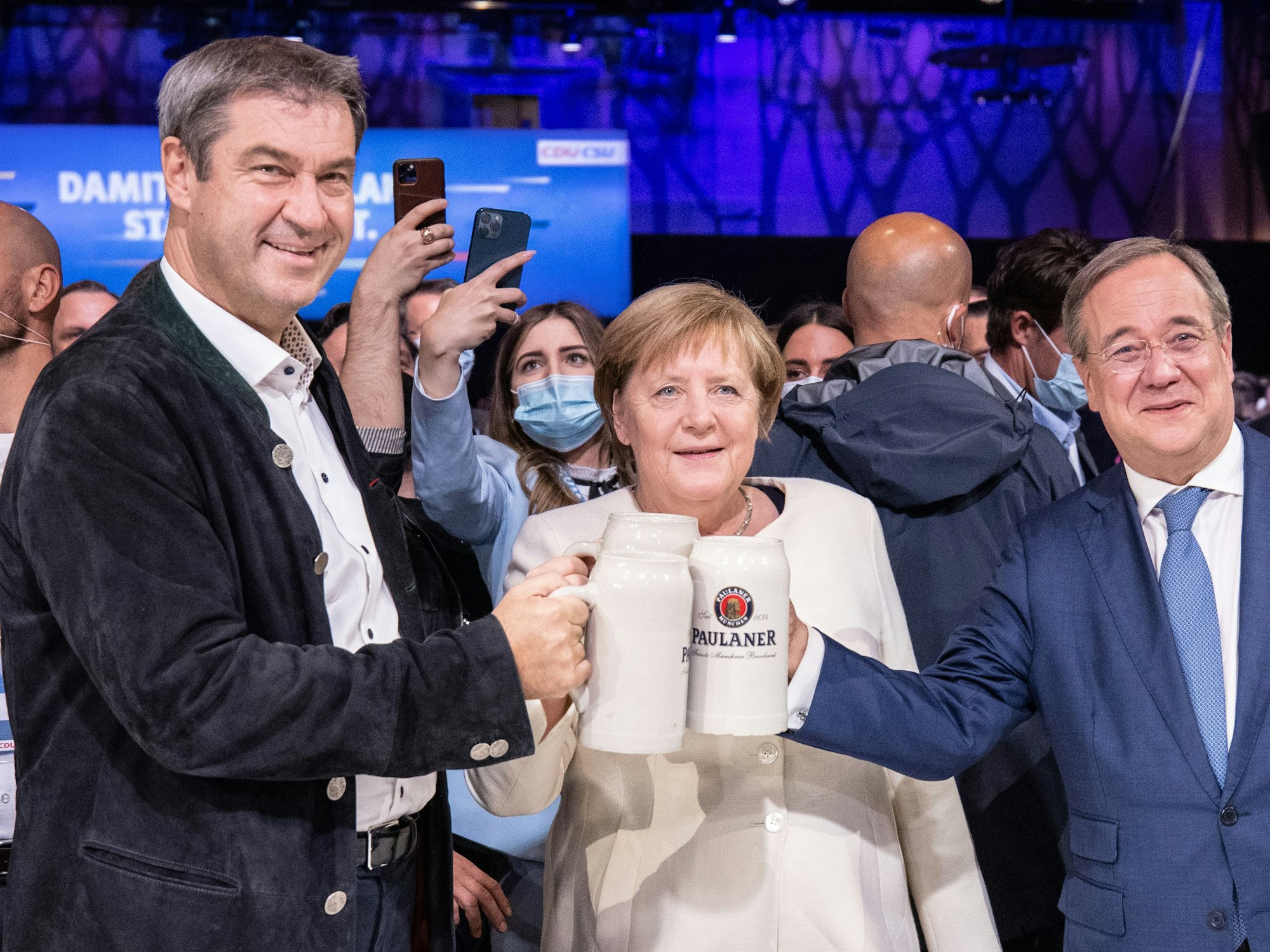 Beim offiziellen Wahlkampfabschluss von CDU und CSU in der Festhalle am Nockherberg stoßen Armin Laschet, Angela Merkel und Markus Söder mit Bierkrügen an.