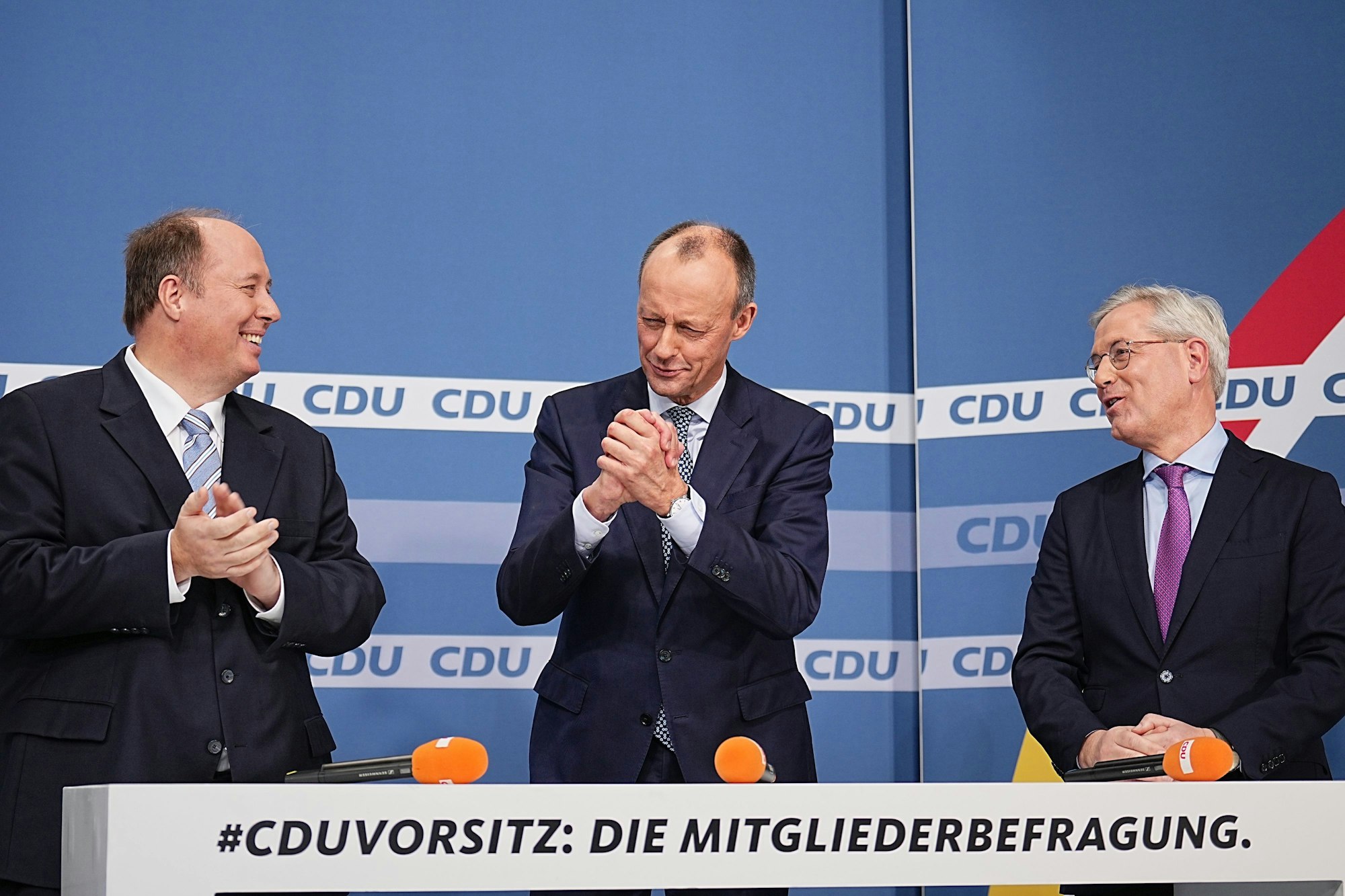 Friedrich Merz steht zwischen den Mitkandidaten für den Parteivorsitz Helge Braun und Norbert Röttgen nach der Bekanntgabe der Ergebnisse der CDU Mitgliederbefragung.