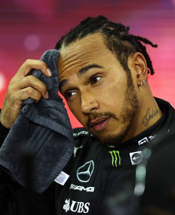 Lewis Hamilton wischt sich den Schweiß von der Stirn.