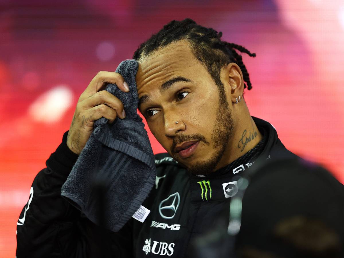 Lewis Hamilton wischt sich den Schweiß von der Stirn.