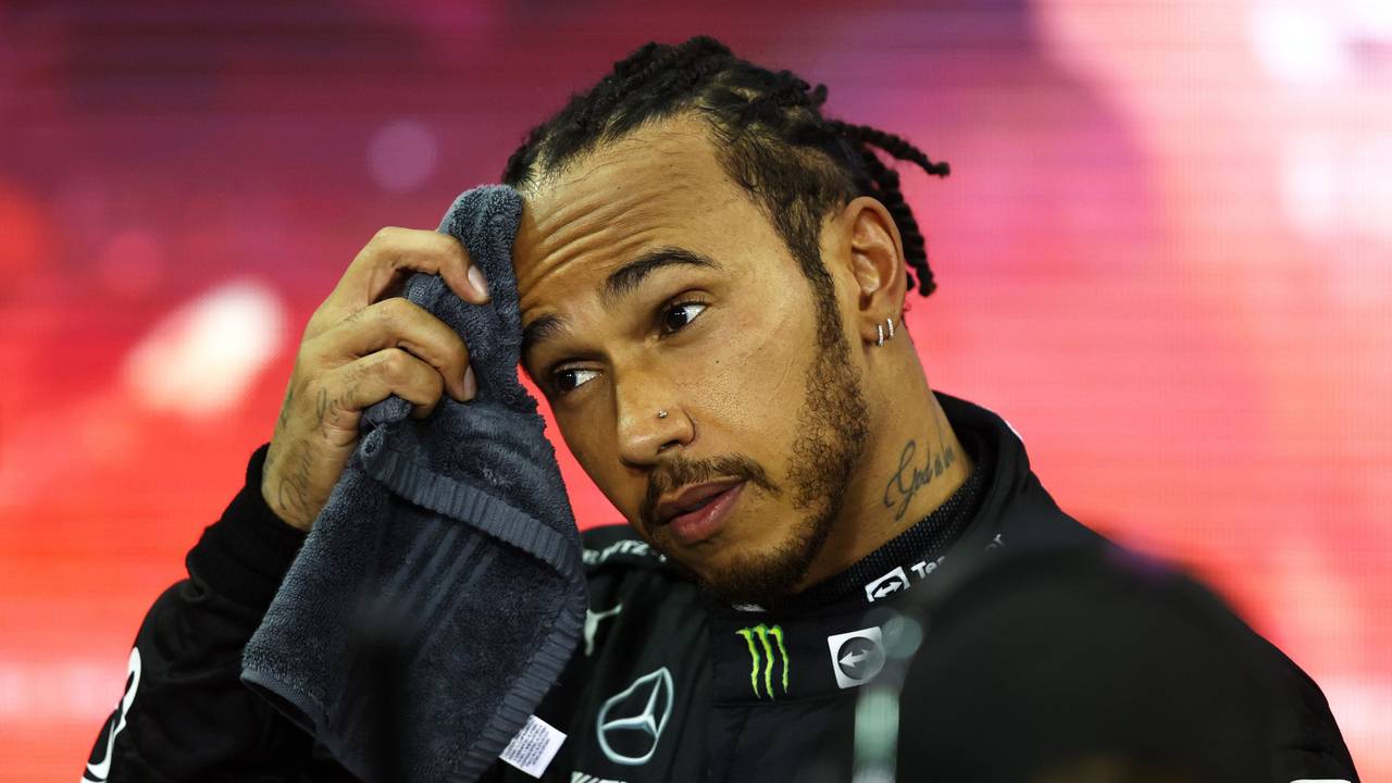 Lewis Hamilton wischt sich den Schweiß von der Stirn.