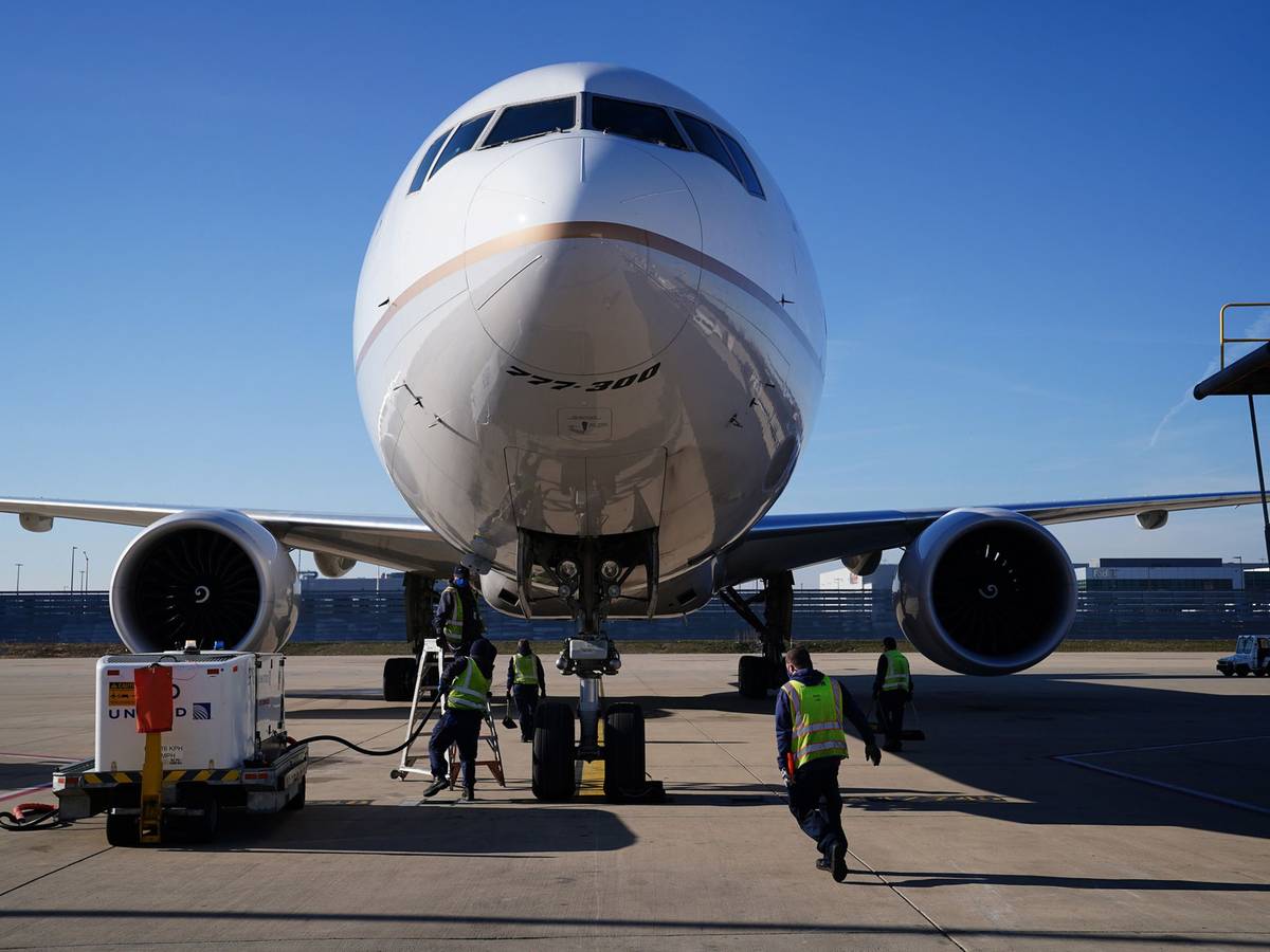 Frachtabfertiger bereiten sich auf das Entladen einer Boeing 777-300 vor.