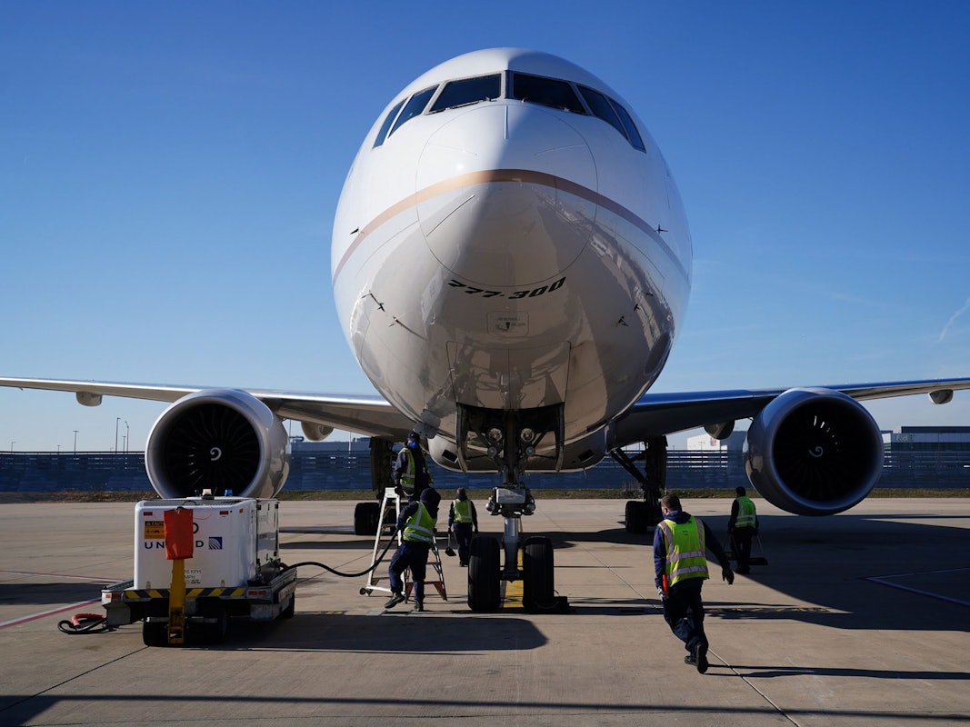Frachtabfertiger bereiten sich auf das Entladen einer Boeing 777-300 vor.