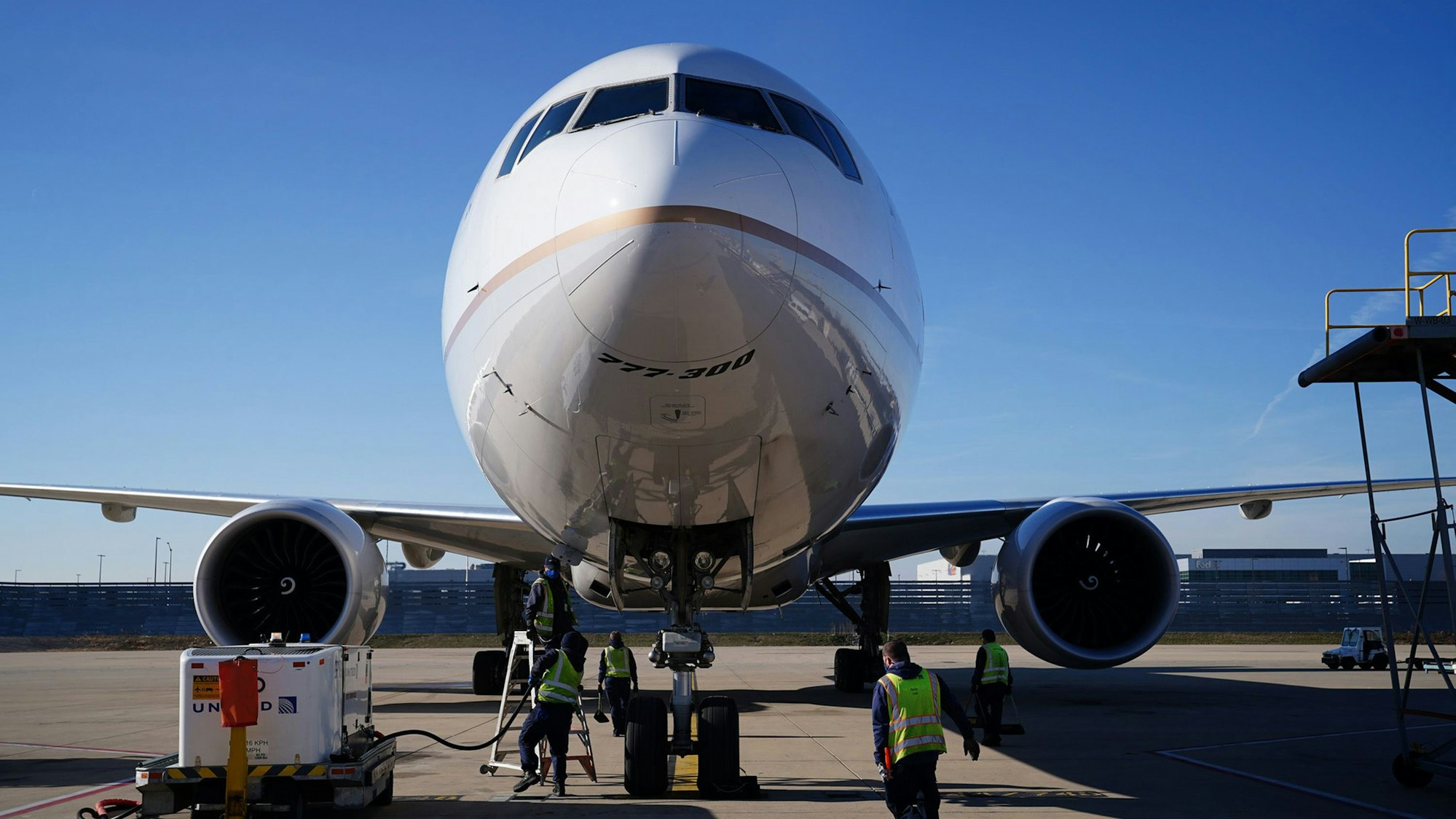 Frachtabfertiger bereiten sich auf das Entladen einer Boeing 777-300 vor.