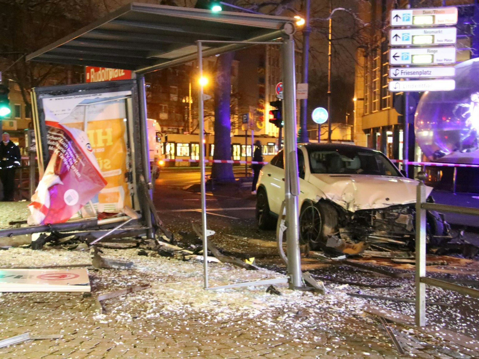 Ein schwer beschädigtes Auto und eine zerstörte Haltestelle nach einem Unfall.