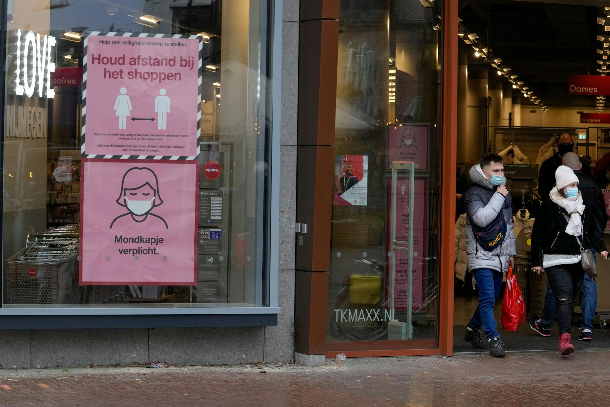 Hinweisschilder sind im Schaufenster eines Geschäftes angebracht, die Kunden auf die Corona-Maßnahmen hinweisen sollen.