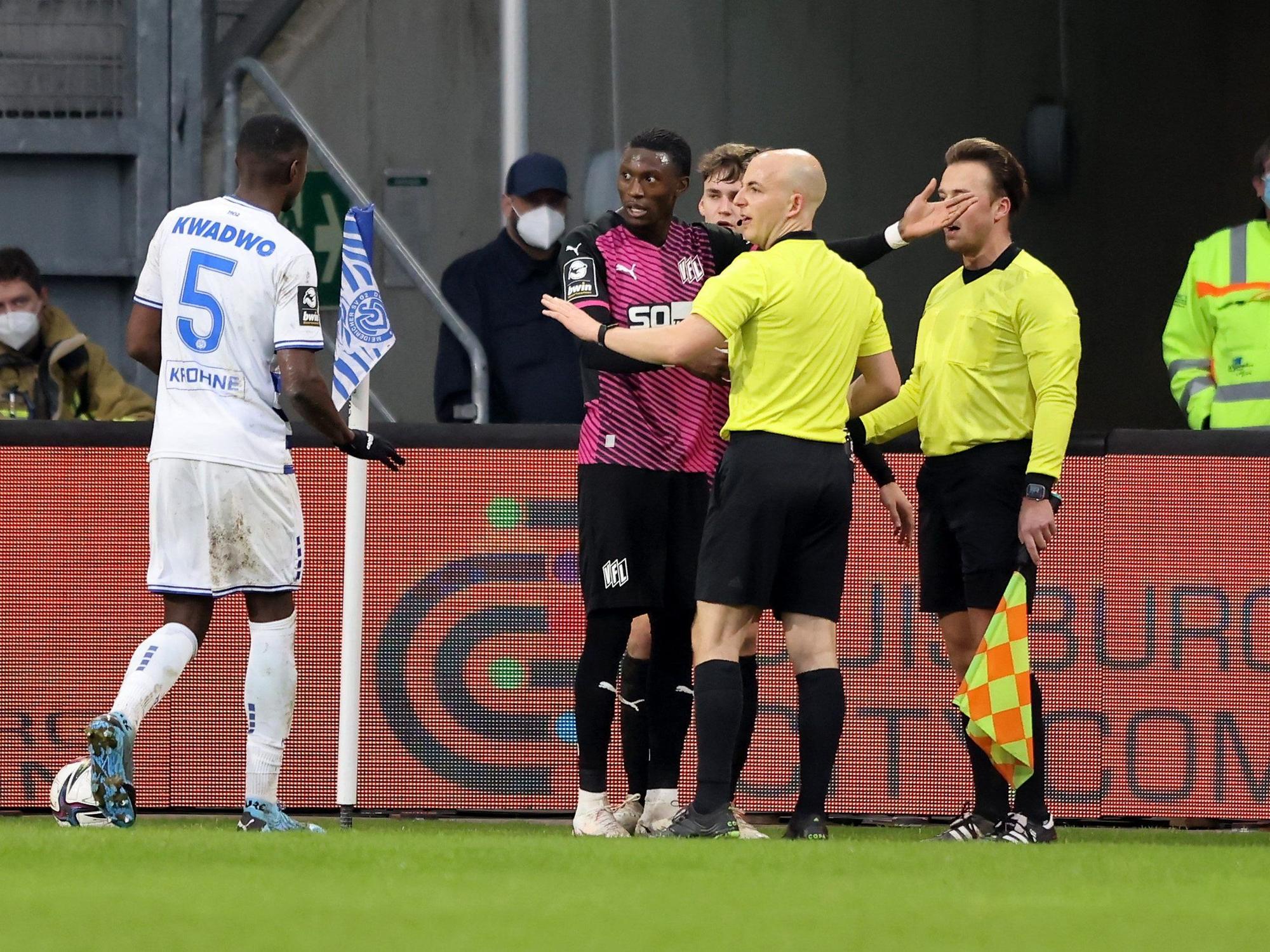 Aaron Opoku spricht mit Schiedsrichter Nicolas Winter und Leroy Kwadwo nachdem er von einem Zuschauer rassistisch beleidigt wurde.
