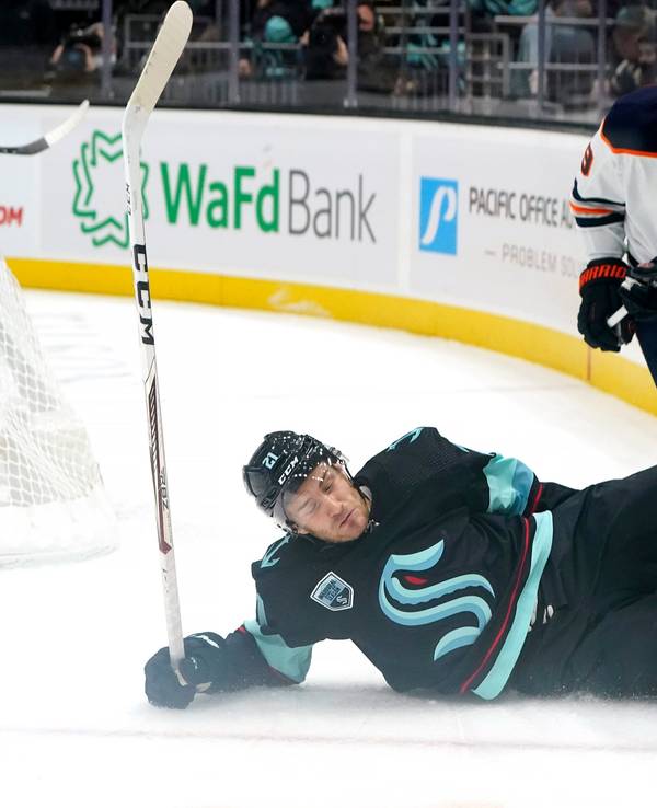 Seattle Kraken's Alex Wennberg, left, skids across the ice in front of Edmonton Oilers' Leon Draisaitl in the first period of an NHL hockey game Saturday, Dec. 18, 2021, in Seattle. (AP Photo/Elaine Thompson)