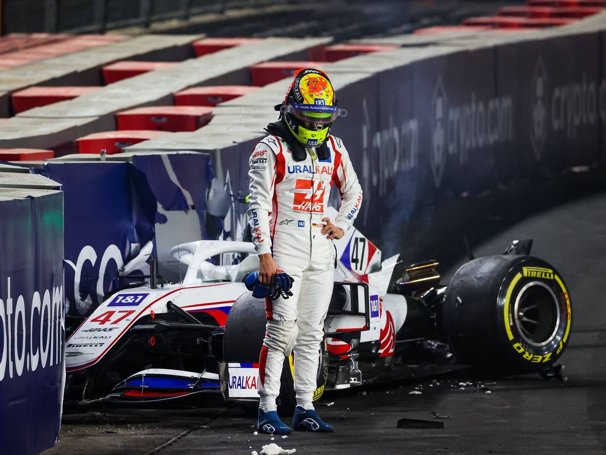 Mick Schumacher steht vor seinem demolierten Auto.