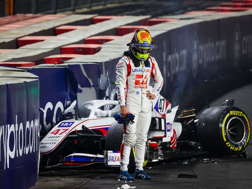 Mick Schumacher steht vor seinem demolierten Auto.