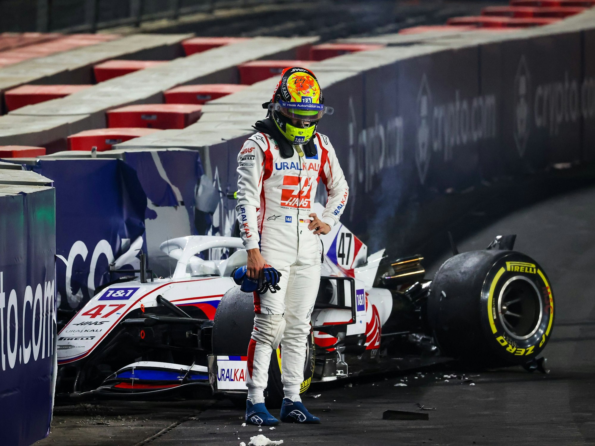 Mick Schumacher steht vor seinem demolierten Auto.