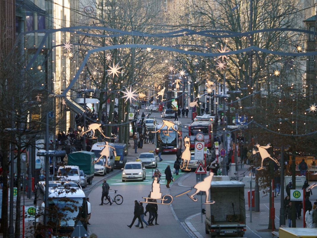 Passanten erledigen Einkäufe am 21. Dezember in der weihnachtlich geschmückten Innenstadt von Hamburg. Das Bundesland verschärft seine Corona-Maßnahmen für Heiligabend.